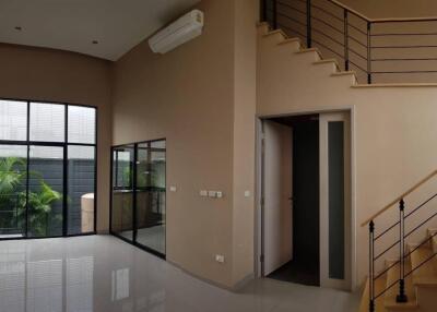 Spacious living room with staircase and large windows