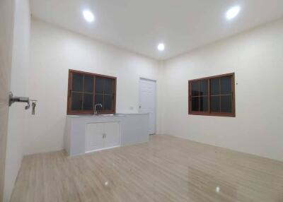 Minimalist kitchen with wooden flooring and white cabinets