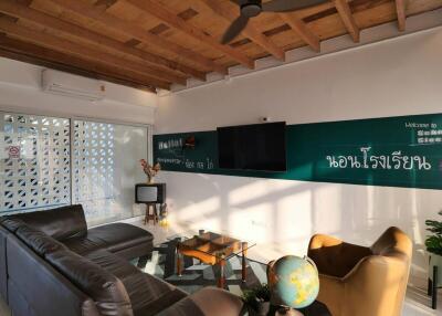 Cozy living room with ceiling fan, wooden ceiling, leather couch, and a globe on a side table