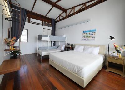 Spacious bedroom with wooden flooring, bunk beds, and a double bed