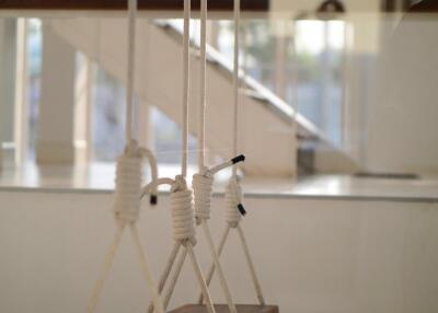 Indoor swings with white ropes and wooden seats