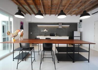 Modern kitchen with wooden ceiling, open shelves, black and wooden furniture, and pendant lighting