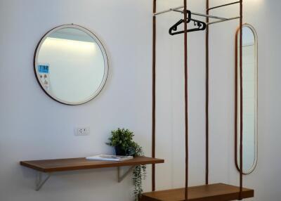 Entryway with floating shelf, hanging seat, and mirrors