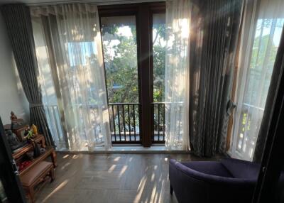 Living area with large windows and light curtains