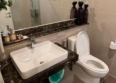 Modern bathroom with sink, toilet, and shower