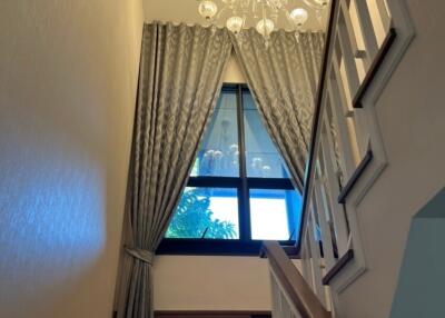 Elegant staircase with chandelier and large window