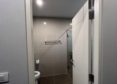 Modern bathroom with grey tiling and glass shower door