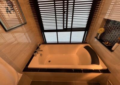 Bathroom with bathtub and window with blinds