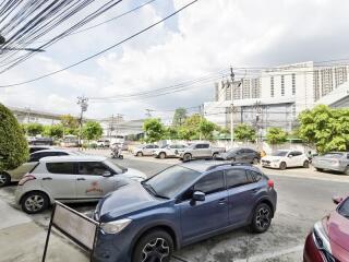 Parking lot with multiple cars and nearby buildings