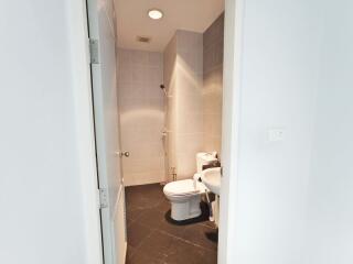 Small bathroom with tiled walls and floor, featuring a toilet and sink