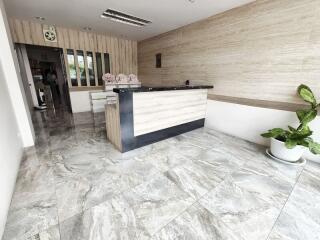 Reception area with a modern front desk and marble flooring