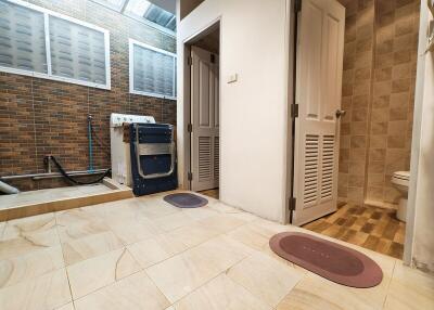 Laundry room with washing machine and connected bathroom