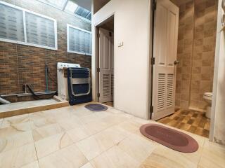 Laundry room with washing machine and connected bathroom