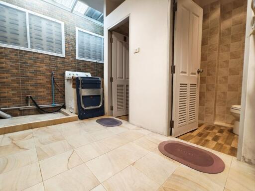 Laundry room with washing machine and connected bathroom