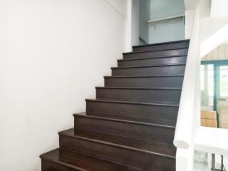 A well-lit staircase with dark wooden steps