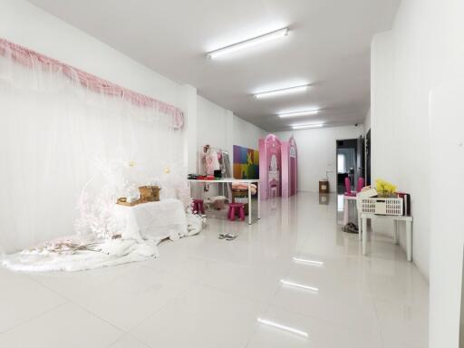 Spacious white room with bright lighting, decorated with various items and dividers