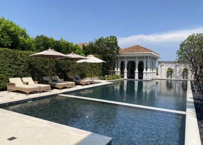 luxurious outdoor pool with lounge chairs and umbrellas