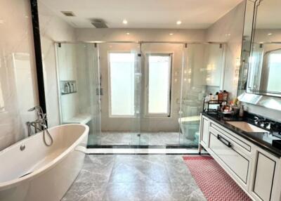 Modern bathroom with bathtub, vanity, and shower area