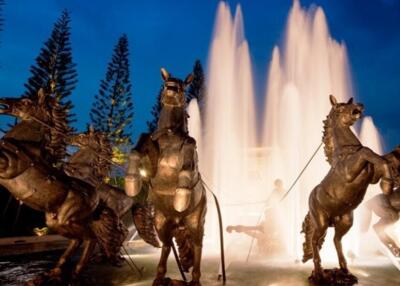 Statue of horses near a fountain at night