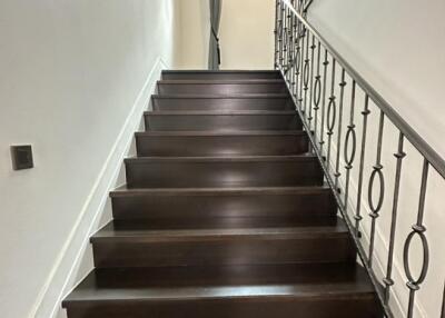 Interior stairway with dark wooden stairs and metal railing