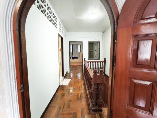 Spacious hallway with wooden flooring and decorative railing