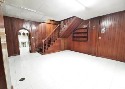 Living room with wooden paneling and stairs