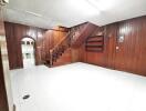 Living room with wooden paneling and stairs