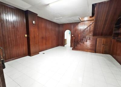 Spacious wooden-paneled living room with staircase