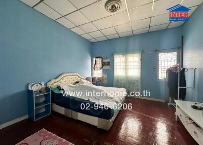 Spacious bedroom with double bed, blue walls, and wooden flooring