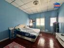 Spacious bedroom with double bed, blue walls, and wooden flooring