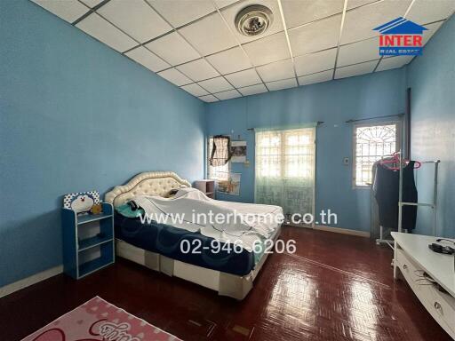 Spacious bedroom with double bed, blue walls, and wooden flooring