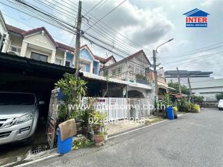 View of residential houses with cars parked outside on a concrete street.