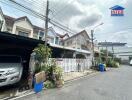 View of residential houses with cars parked outside on a concrete street.