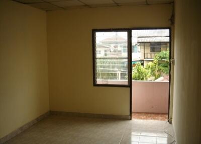 Empty bedroom with tiled floor and a window with an outdoor view