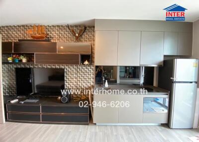 Modern kitchen area with cabinets, countertop, refrigerator, and wall storage