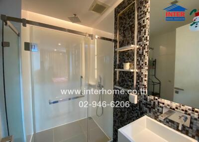 Modern bathroom with glass shower enclosure and tiled wall