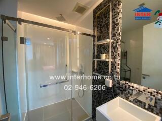 Modern bathroom with glass shower enclosure and tiled wall