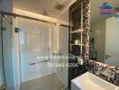 Modern bathroom with glass shower enclosure and tiled wall