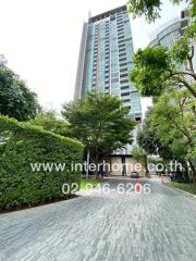 Vertical view of a modern high-rise building with landscaped pathway and greenery.