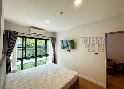 Modern bedroom with large windows and wall-mounted TV