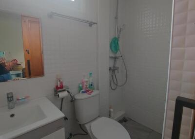 Modern bathroom with shower, sink, toilet, and mirror