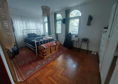 Bedroom with bed, decorative rug, windows, and furniture