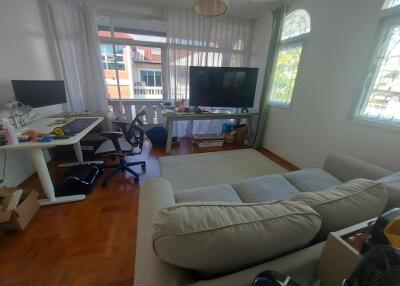 Living room with office area, large window, and TV