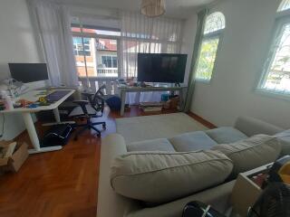 Living room with office area, large window, and TV