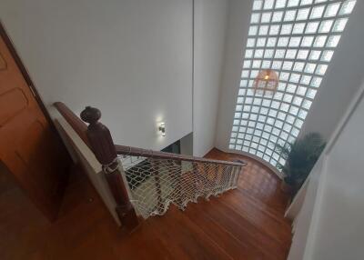 Staircase with wooden steps and glass block wall