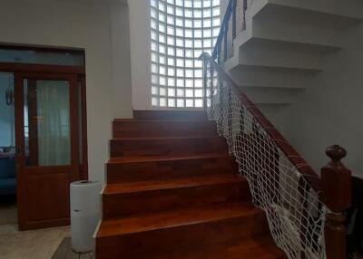 Staircase area with wooden steps and glass block wall