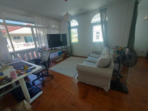 Well-lit living room with a working desk and seating area