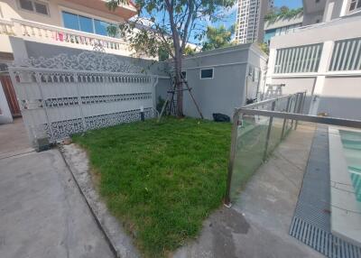 Small yard with grass, fence, and pool