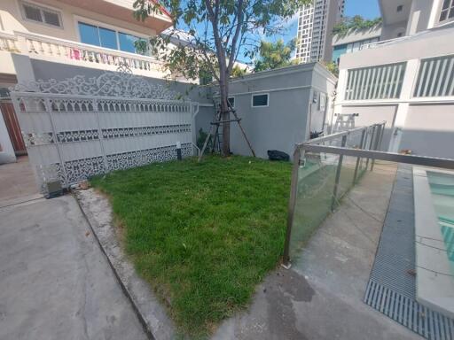 Small yard with grass, fence, and pool