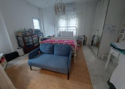 Cozy Bedroom with a Small Couch and Decorative Chandelier